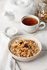 Muesli granola with raisin and yogourt in white bowl
