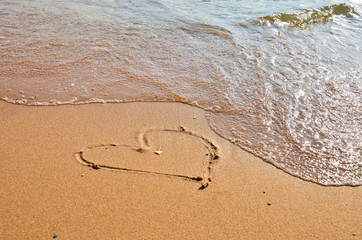 Inscription love on the wet sand of the sea