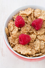 flakes with raspberries on red bowl