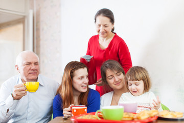 Obraz na płótnie Canvas family having tea with cakes at home together