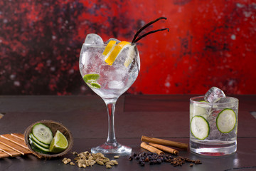 Gin tonic cocktail with spices in red grunge background