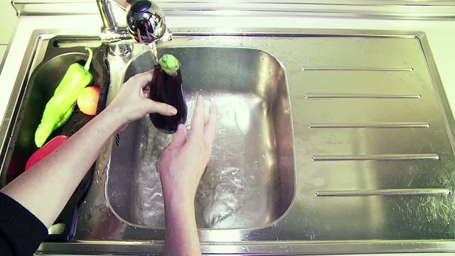 Lavado de berenjena, pimiento y tomate en la pila