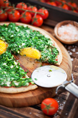 Pizza from oat bran with spinach, green onions and eggs