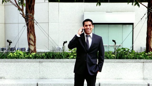 Handsome hispanic businessman talking at phone