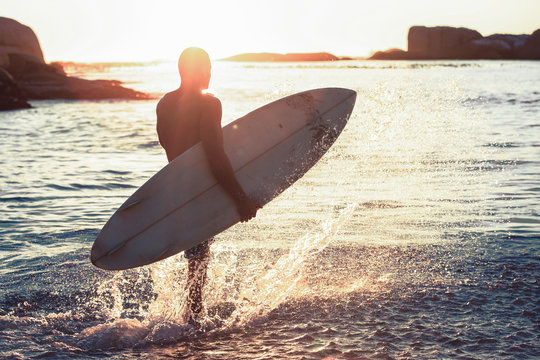 Silhouette of a surfer walking in the sea