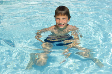 Activities on the pool. Cute boy swimming and playing in water i