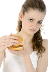 Schülerin schaut angewidert in Cheeseburger