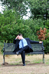 Fototapeta premium Stressed Businessman On Park Bench