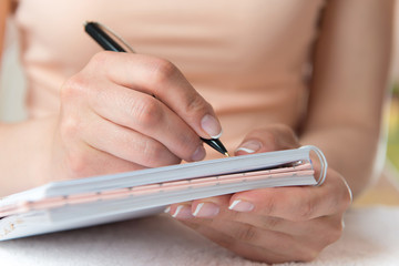 Young female is writing notes