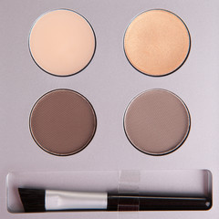 Set of beige eyeshadows and applicator brush
