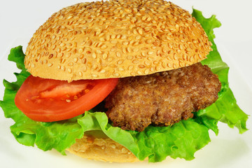 burger with beef, tomato and bun with sesame seeds