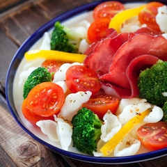 Gluten-free pasta with cherry tomatoes, broccoli and bresaola