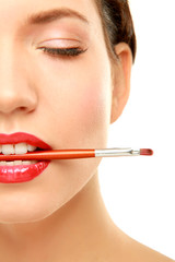 Woman's lips holding make up brush