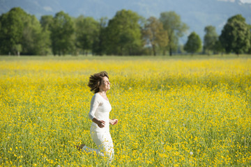 Fototapeta premium Frau läuft durch Blumenwiese.