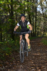 Fototapeta na wymiar A mountain biker riding through a trail.