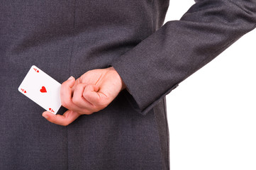 Businessman holding playing card behind his back.