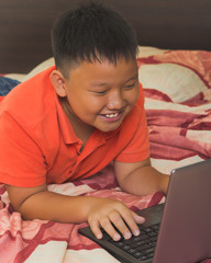 Asian boy working on a laptop computer