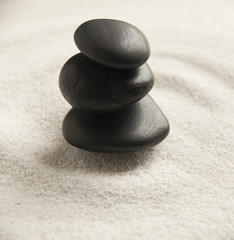 Fototapeta na wymiar pierres noires zen dans le sable