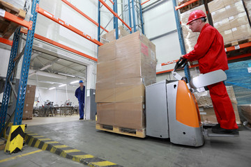 forklift loader with cardboard freight moving in storehouse