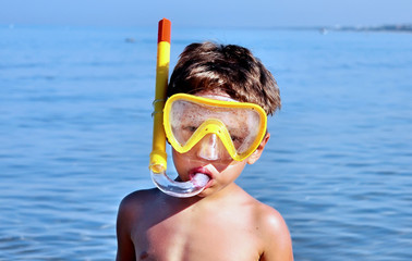 Bambino abbronzato indossa la maschera da sub e boccaglio