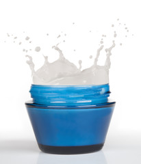 Jar of cream with splash, isolated on white background