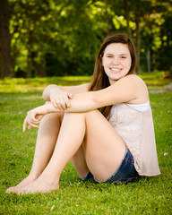 Naklejka na ściany i meble Portrait of happy teenage or adolescent girl outdoors