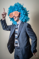 funny businessman with big orange glasses and blue wig