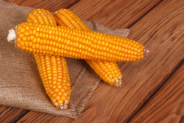 corn on the cob on a brown wooden table
