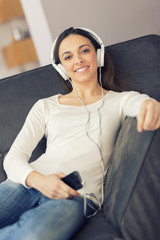 Relaxed woman listening to music on the sofa at home