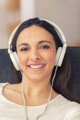 Relaxed woman listening to music on the sofa at home