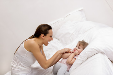 Mother and daughter playing on the bed
