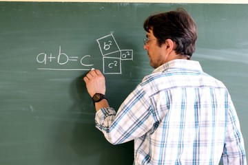 Lehrer schreibt Formel an die Tafel