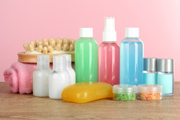 Hotel amenities kit on table on pink background