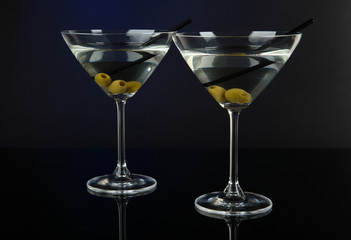 Martini glasses with olives on dark blue background