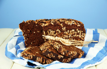 Hot tasty bread, on wooden table, on color background