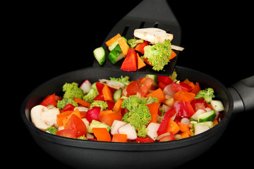 Vegetable ragout in pan, isolated on black
