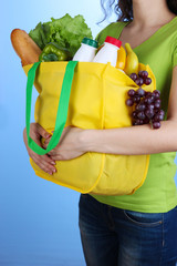 Girl with shopping bag on blue background