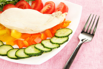 Boiled chicken breast on plate with vegetables close up