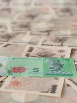 Malaysian ringgit note isolated on Japanese yen note background