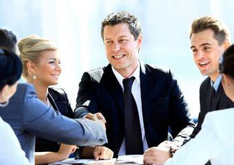 Two business colleagues shaking hands during meeting