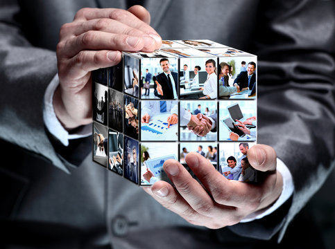 man holding abstract cube with business images