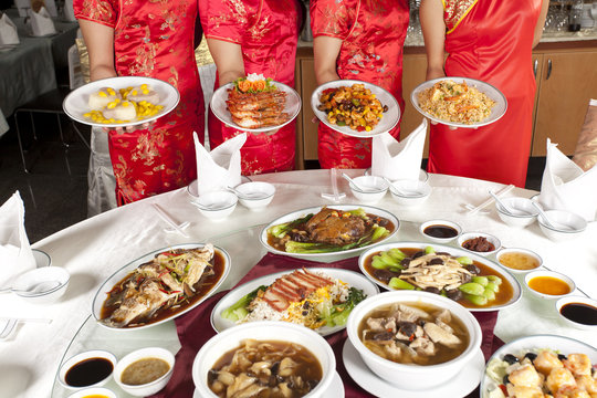 Chinese food, full rounded table of Chinese food with waitress