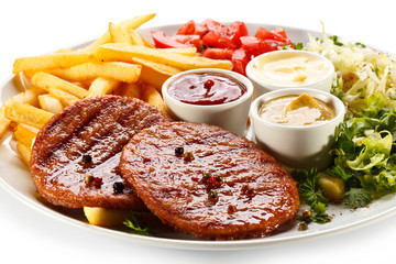 Grilled steaks, French fries and vegetables