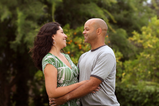 A happy mixed race couple relax outside