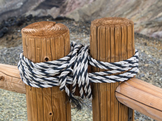 Two parts of a wooden fence tied together by the rope
