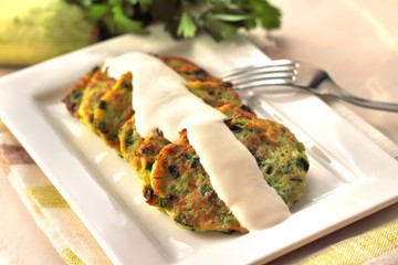 Zucchini pancakes with green onions and sour cream