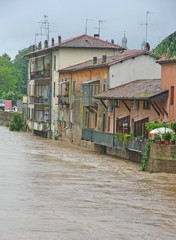 houses near the shore of the raging river during the flood