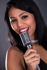 Young Woman Singing In Microphone