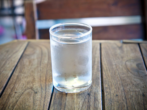 Glass with water on wood background