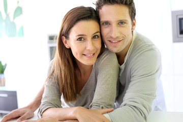 Portrait of cheerful couple standing at home